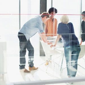 A group of people standing around in an office.