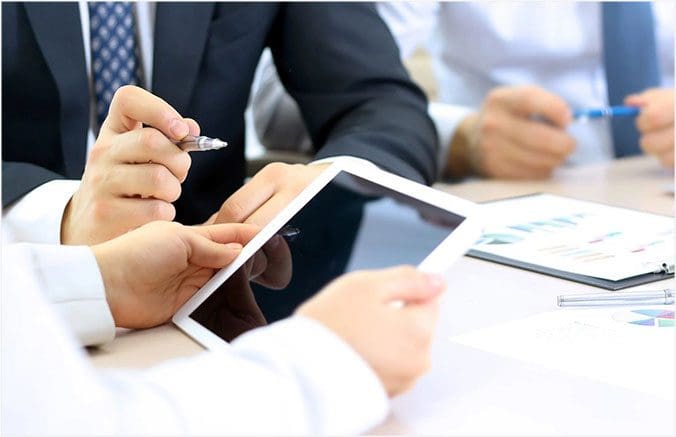 A group of people sitting at a table with papers.