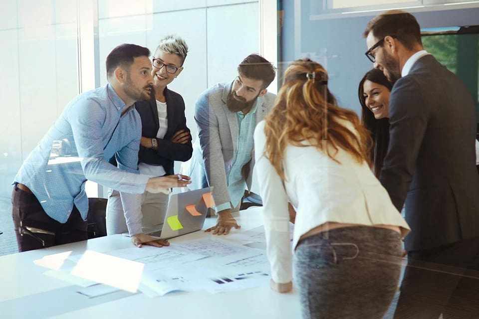 A group of people standing around a table.