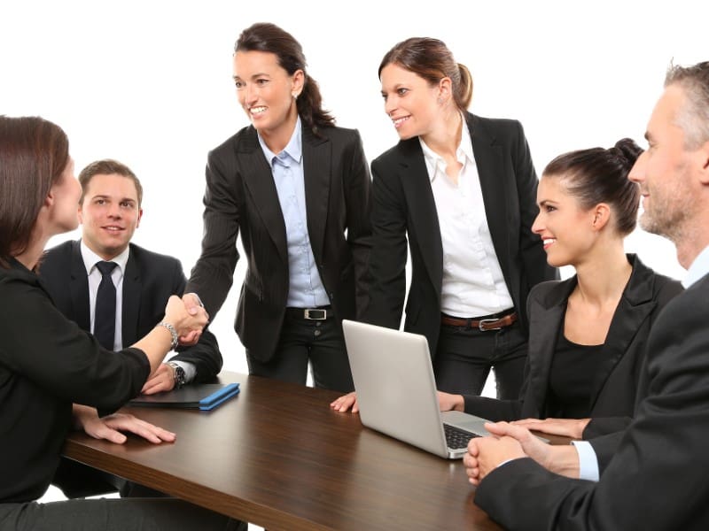 A group of people in suits sitting at a table.